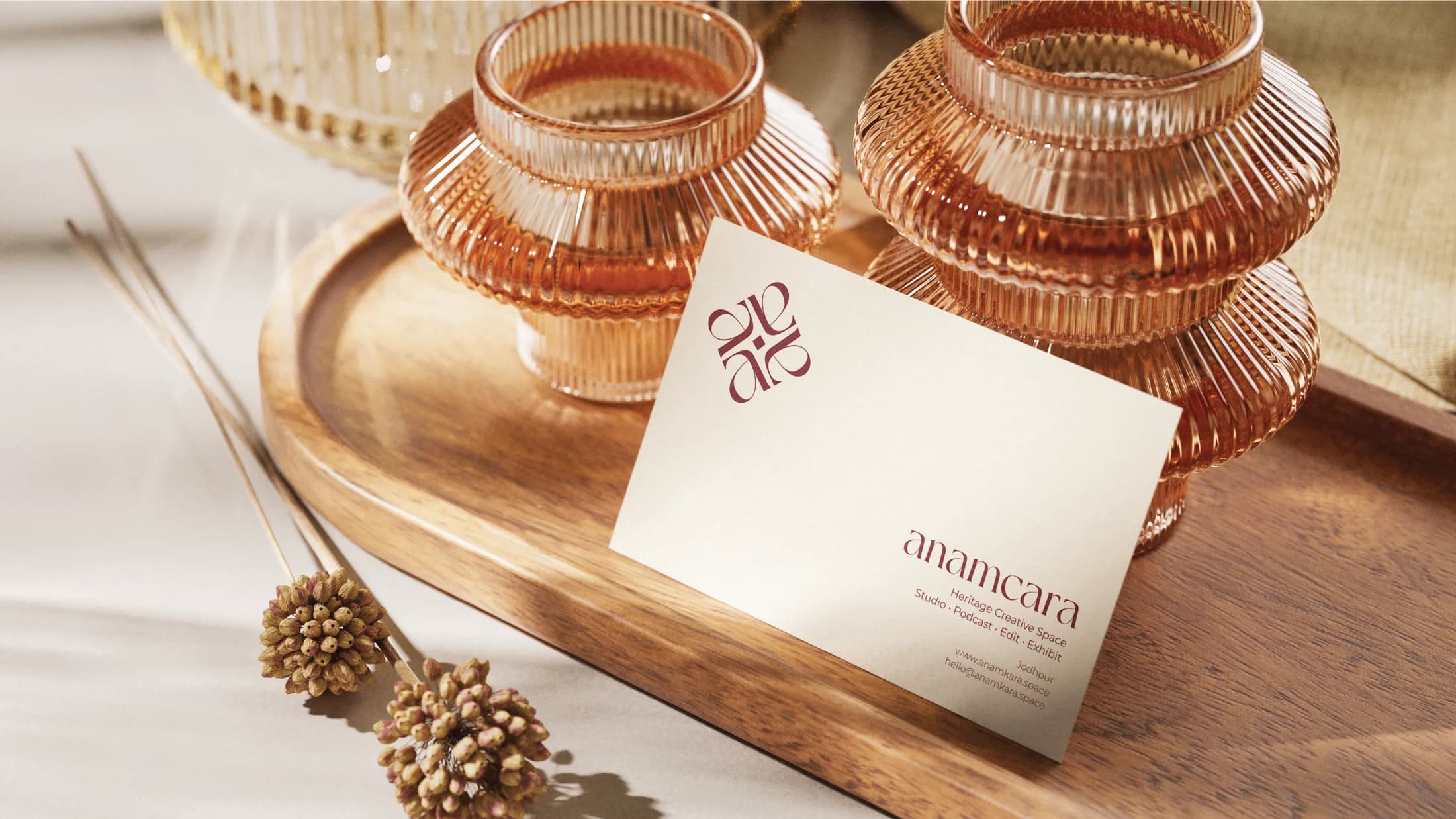 Business card with the maroon monogram among amber glassware